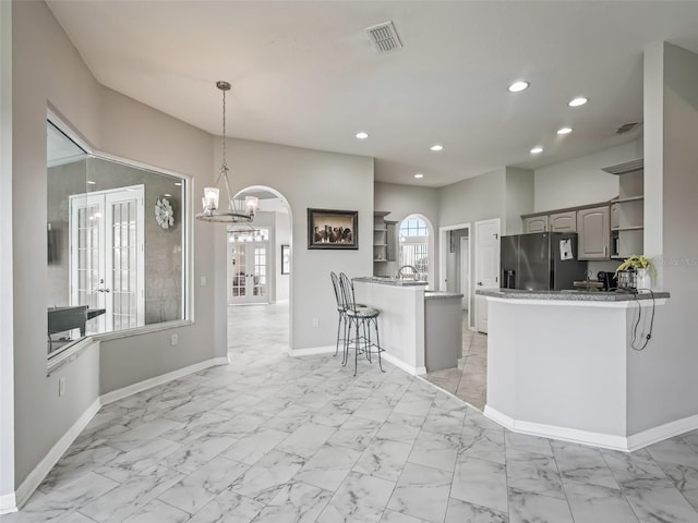 kitchen featuring a peninsula, recessed lighting, open shelves, and stainless steel fridge with ice dispenser