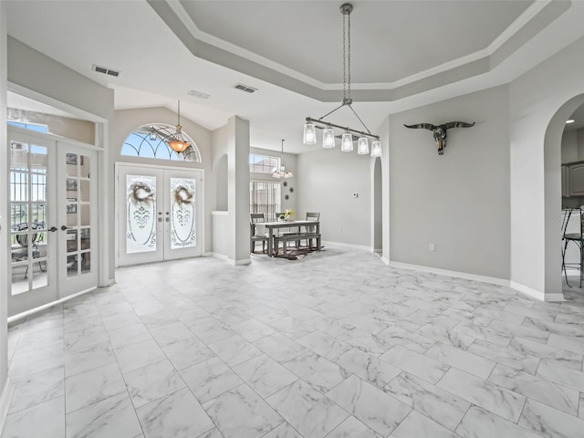 entrance foyer featuring arched walkways, french doors, marble finish floor, and baseboards