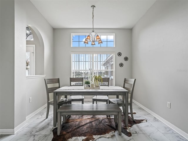 dining room with marble finish floor, an inviting chandelier, and baseboards