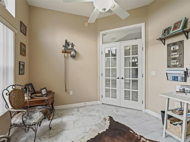 sitting room with marble finish floor, french doors, a ceiling fan, and baseboards