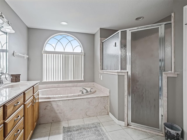 full bathroom with tile patterned flooring, a garden tub, a shower stall, and vanity