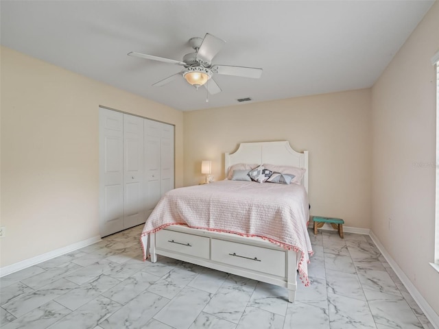 bedroom featuring marble finish floor, a closet, visible vents, a ceiling fan, and baseboards