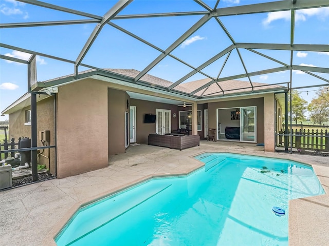 pool with glass enclosure, a patio, fence, and an outdoor hangout area