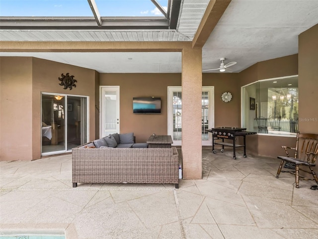 living room featuring ceiling fan and beamed ceiling