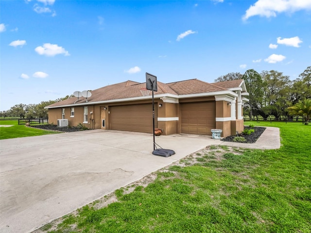 exterior space featuring a yard, stucco siding, concrete driveway, fence, and a garage