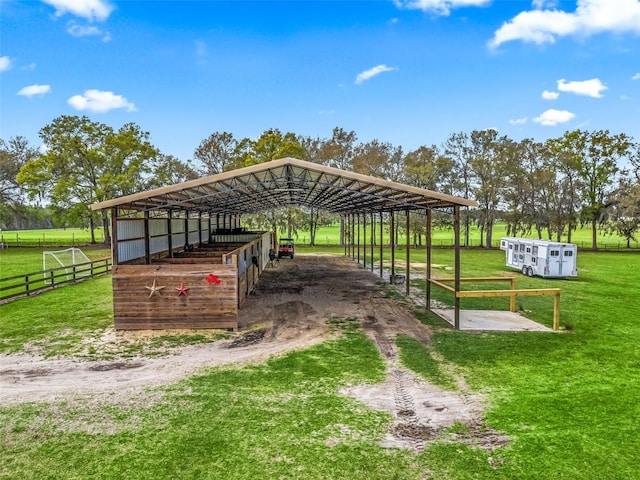 view of property's community featuring driveway, a detached carport, an exterior structure, and an outdoor structure