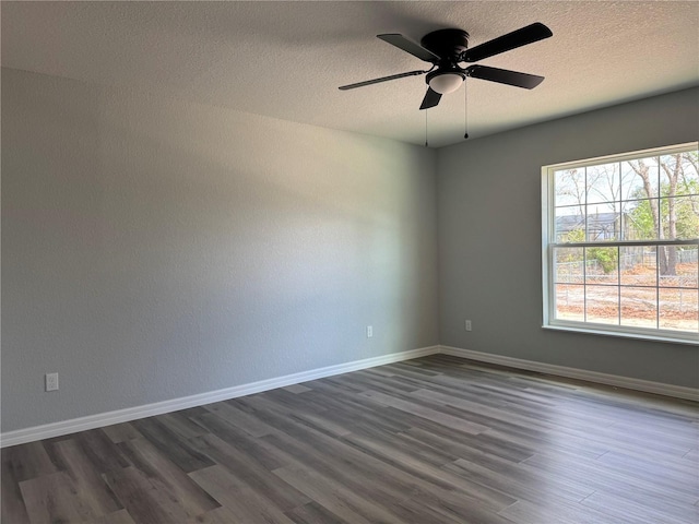 unfurnished room featuring a ceiling fan, baseboards, dark wood finished floors, and a textured ceiling