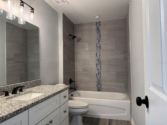 full bath with a textured wall, toilet, a textured ceiling, shower / tub combination, and wood finished floors