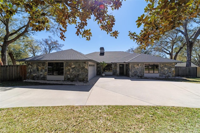 single story home with a garage, fence, stone siding, driveway, and a chimney