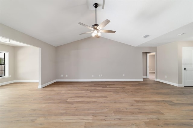 unfurnished room featuring ceiling fan, light wood-style flooring, visible vents, baseboards, and vaulted ceiling