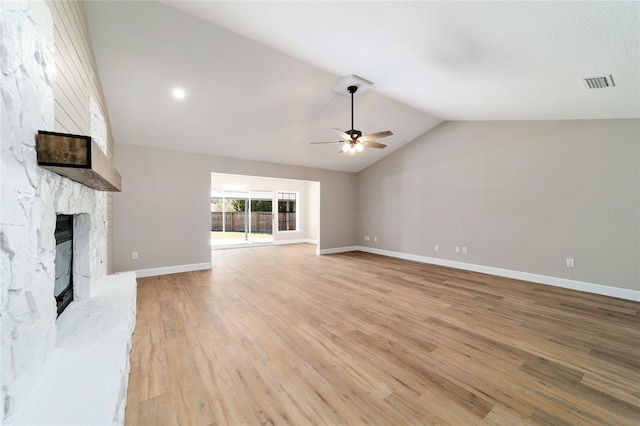 unfurnished living room with lofted ceiling, visible vents, a fireplace, and light wood finished floors