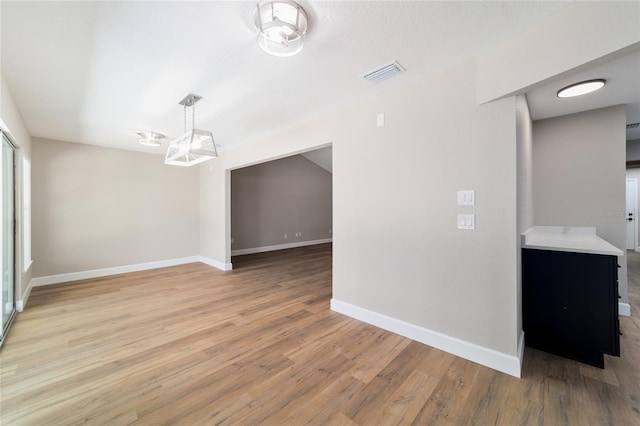 unfurnished room with light wood finished floors, baseboards, and visible vents