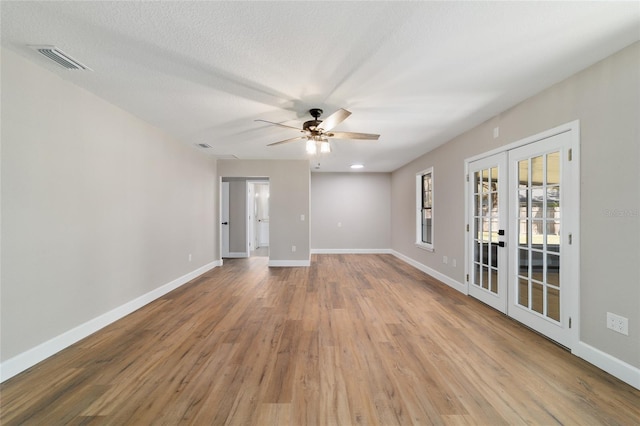 spare room featuring french doors, visible vents, baseboards, and wood finished floors