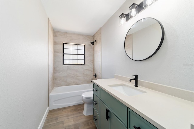 bathroom featuring baseboards, toilet, wood finished floors, vanity, and shower / washtub combination