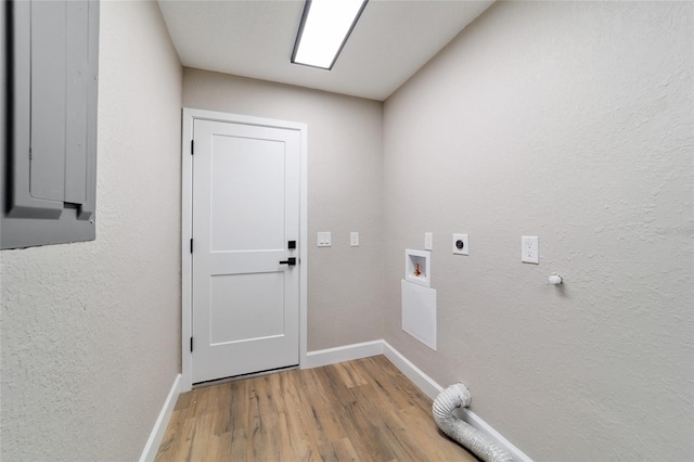 clothes washing area with hookup for a washing machine, hookup for an electric dryer, wood finished floors, laundry area, and baseboards