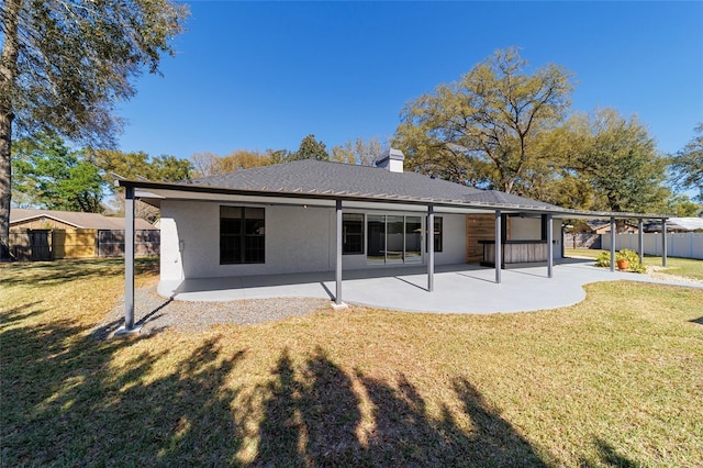 back of property with a chimney, fence, a lawn, and a patio