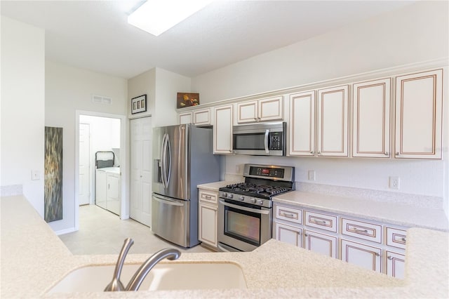 9458 SW 93rd Loop, Ocala, FL 34481 - kitchen with appliances with stainless steel finishes, independent washer and dryer, cream cabinetry, and light countertops