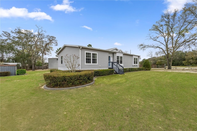 manufactured / mobile home featuring a front lawn and fence