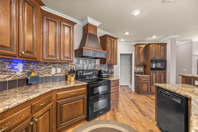 kitchen featuring light wood finished floors, custom exhaust hood, ornamental molding, black appliances, and tasteful backsplash