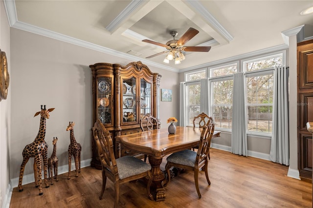 dining space featuring baseboards, light wood-type flooring, and ornamental molding