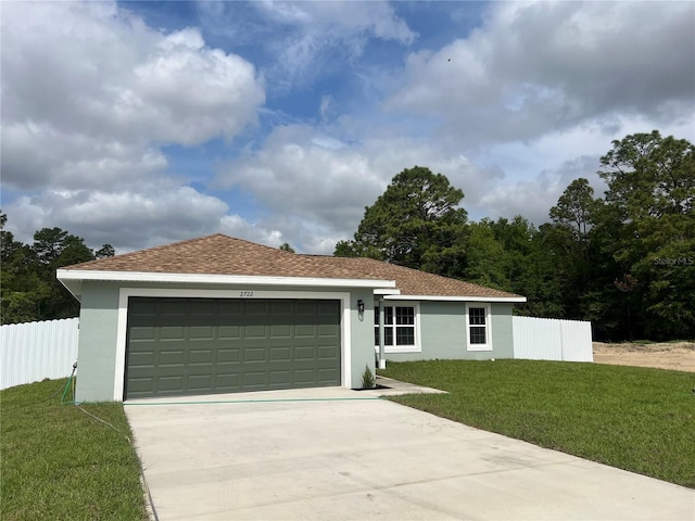 view of front of property with driveway, fence, a front yard, a garage, and stucco siding