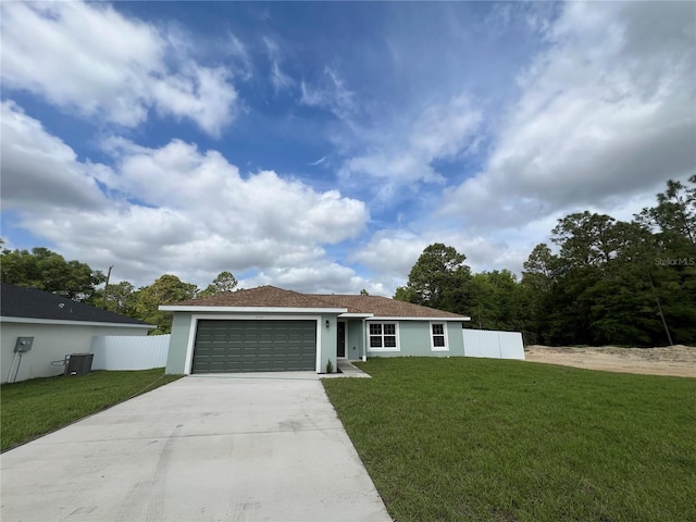 ranch-style house featuring fence, an attached garage, a front lawn, and driveway