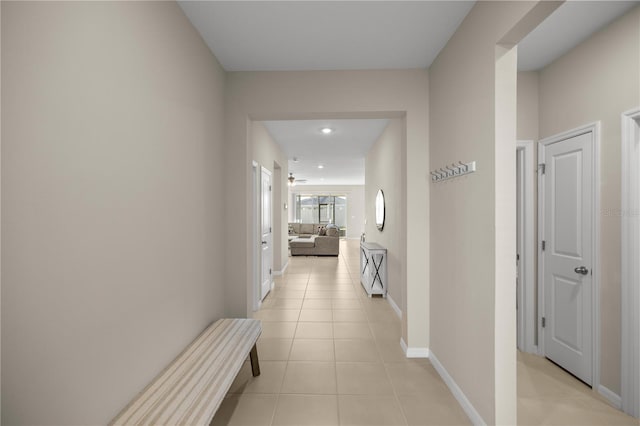 hallway with light tile patterned flooring and baseboards