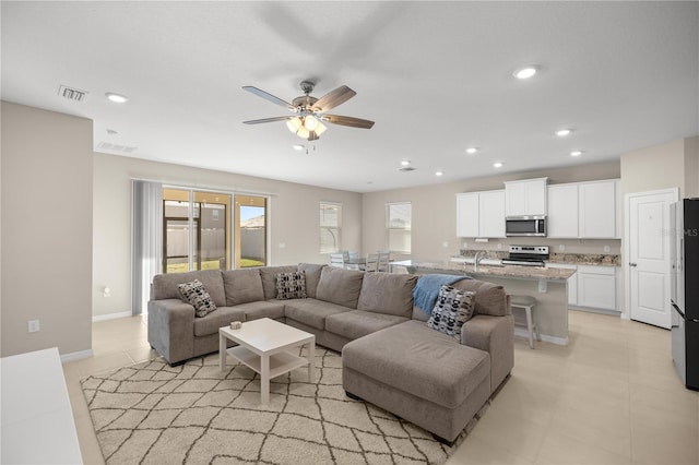 living area with visible vents, recessed lighting, baseboards, and a ceiling fan