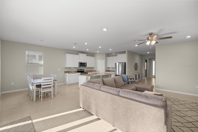 living room with light tile patterned flooring, recessed lighting, baseboards, and ceiling fan