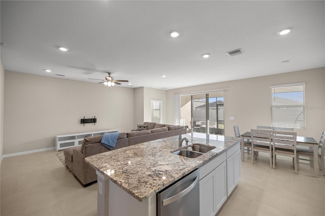 kitchen featuring visible vents, a center island with sink, stainless steel dishwasher, white cabinetry, and a sink