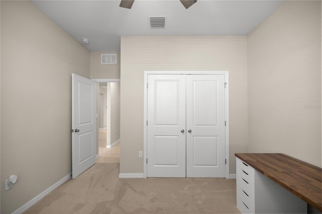 unfurnished bedroom with light colored carpet, visible vents, a closet, and baseboards