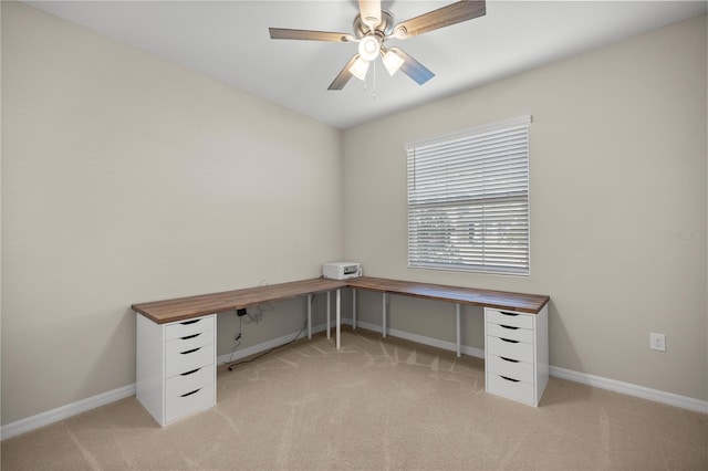 unfurnished office with baseboards, light colored carpet, and ceiling fan