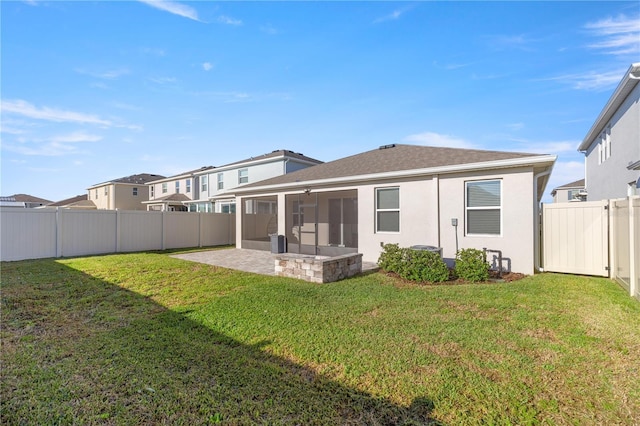 back of property with a patio area, a fenced backyard, a yard, and a sunroom