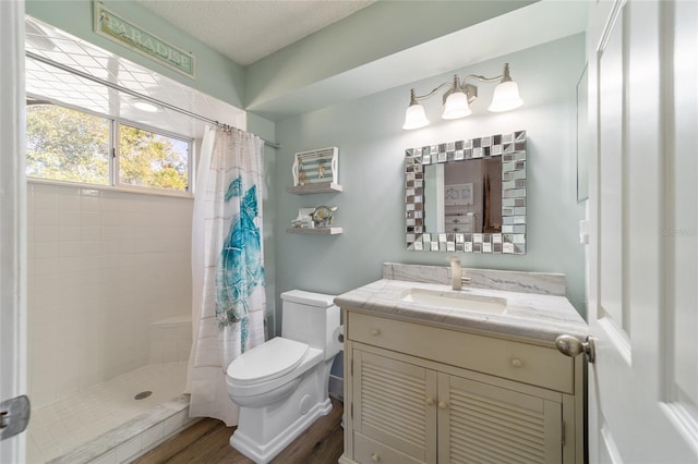 full bath featuring vanity, toilet, a stall shower, and a textured ceiling