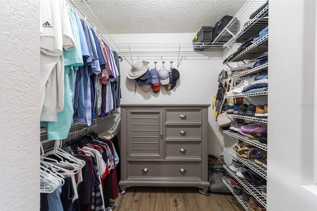 walk in closet with dark wood-style flooring