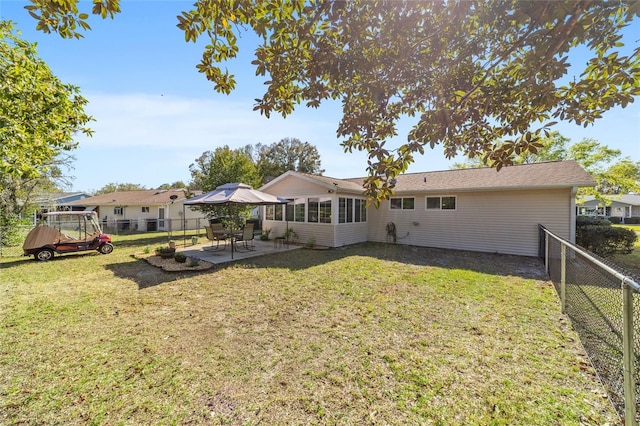 rear view of property with a lawn, a fenced backyard, and a patio area