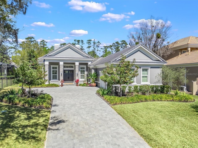 view of front of house featuring decorative driveway, a garage, a front lawn, and stucco siding