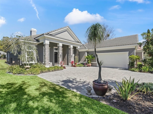 view of front of house featuring decorative driveway, an attached garage, fence, and stucco siding