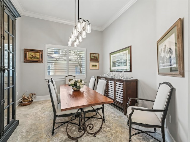 dining room with an inviting chandelier, baseboards, and ornamental molding