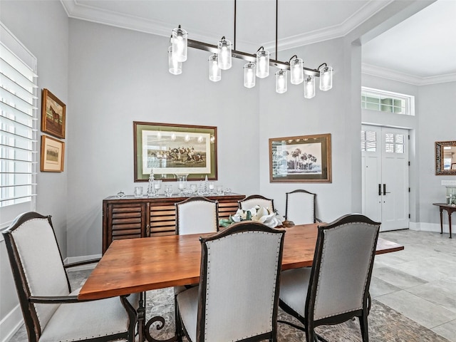 dining room featuring light tile patterned floors, baseboards, and ornamental molding