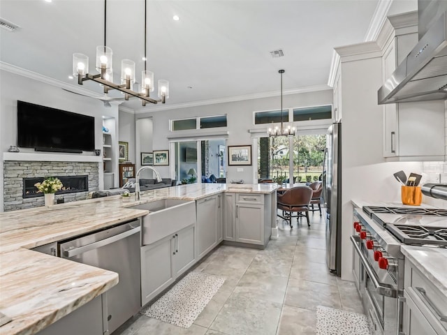 kitchen featuring a notable chandelier, a sink, open floor plan, ventilation hood, and stainless steel appliances