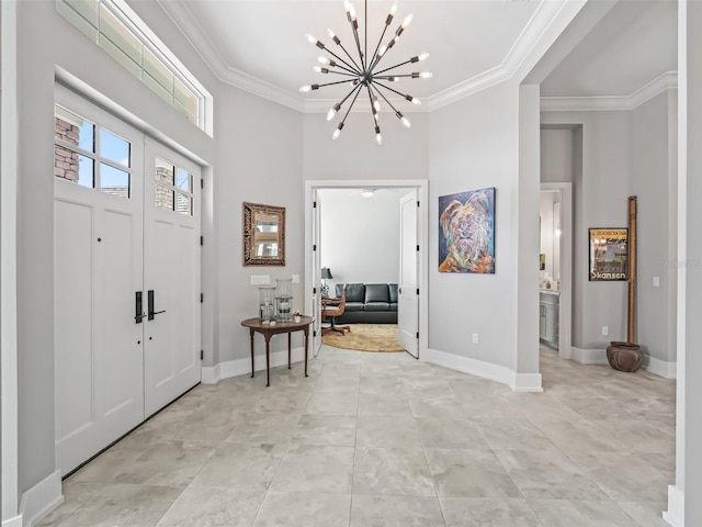 foyer with baseboards, a chandelier, and crown molding