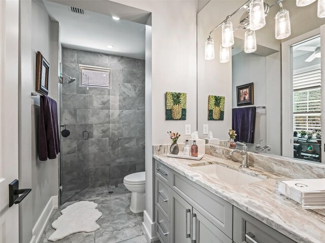 full bathroom with vanity, a shower stall, toilet, and a wealth of natural light