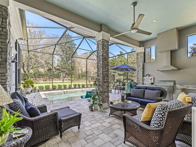 view of patio / terrace featuring an outdoor living space, glass enclosure, an outdoor kitchen, a grill, and a ceiling fan