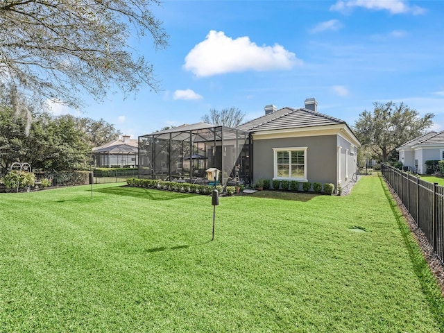 view of yard with glass enclosure and a fenced backyard