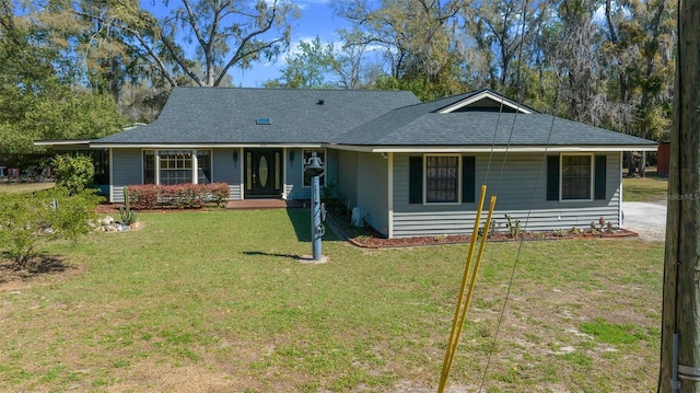 ranch-style home featuring a front yard and roof with shingles