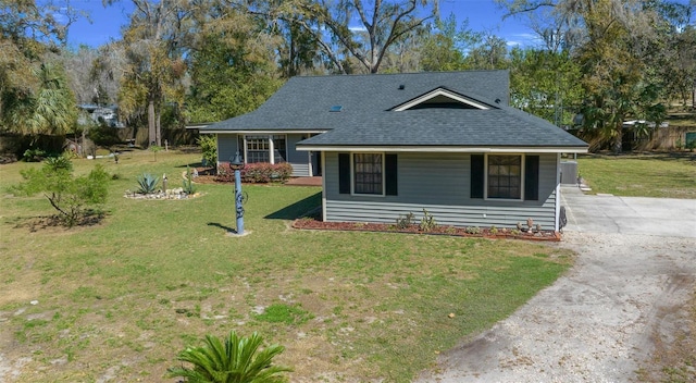 bungalow featuring a front yard, dirt driveway, and roof with shingles