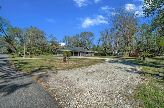 view of front of property with gravel driveway and a front yard