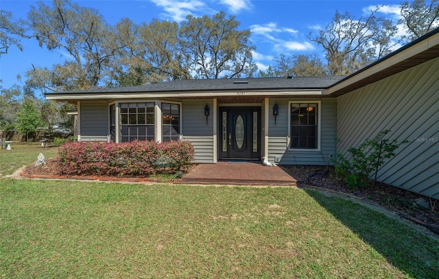 entrance to property featuring a yard