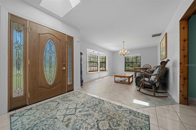 entryway featuring a skylight, visible vents, light tile patterned flooring, and a chandelier